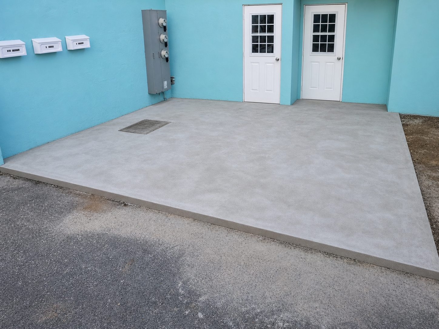 Finished concrete slab outside a turquoise Bermuda building